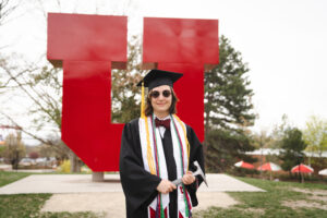 Autumn Hartley in graduation regalia in front of the block U.